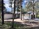 Charming single-story home with light colored exterior paint, dark roof, and surrounded by pine trees at 14546 Pine View Rd, Larkspur, CO 80118
