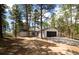 House exterior with detached garage surrounded by trees, featuring a driveway and modern design at 14546 Pine View Rd, Larkspur, CO 80118