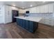 Large kitchen island with quartz countertops and dark cabinets, complemented by modern appliances at 14546 Pine View Rd, Larkspur, CO 80118