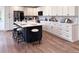 Well-designed kitchen with white cabinets, dark hardware, dark kitchen island, and bar stool seating at 14546 Pine View Rd, Larkspur, CO 80118