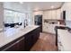 Contemporary kitchen featuring a dark island with quartz countertops, stainless appliances and wood floors at 14546 Pine View Rd, Larkspur, CO 80118