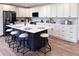 Modern kitchen featuring white cabinets, dark island with white countertop, and seating for four at 14546 Pine View Rd, Larkspur, CO 80118