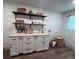 Neat laundry room featuring storage cabinets with butcher block counters, woven baskets, and organized shelving at 14546 Pine View Rd, Larkspur, CO 80118