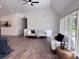 Spacious living area with wood floors, neutral furniture, high ceilings, and views of outdoor greenery at 14546 Pine View Rd, Larkspur, CO 80118