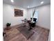 Simple office with a small desk, comfortable chair, wood floors, neutral rug, and natural light at 14546 Pine View Rd, Larkspur, CO 80118