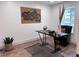 Compact office featuring a small desk, comfortable chair, natural lighting, wood floors, and rustic decor at 14546 Pine View Rd, Larkspur, CO 80118