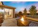 Back deck at dusk featuring a fire pit, built-in seating, and a view of the nearby home interior at 7734 Blue Water Dr, Castle Rock, CO 80108