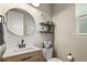 Well-lit half bathroom with decorative shelves, wood-look cabinets, and a modern faucet at 7734 Blue Water Dr, Castle Rock, CO 80108