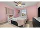 A charming bedroom featuring pink walls, a comfortable bed, and a ceiling fan for added comfort at 7734 Blue Water Dr, Castle Rock, CO 80108