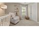 A cozy Bedroom with a crib, comfortable glider, shelving, and a window for soft, natural lighting at 7734 Blue Water Dr, Castle Rock, CO 80108