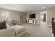 Bright living room featuring neutral walls and carpet, comfortable sectional sofa, and entertainment center at 7734 Blue Water Dr, Castle Rock, CO 80108
