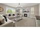 Spacious living room with a stone fireplace, neutral walls and carpet, and a modern chandelier at 7734 Blue Water Dr, Castle Rock, CO 80108