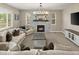 Cozy living room with stone fireplace, neutral walls and carpet, sofas, and a decorative chandelier at 7734 Blue Water Dr, Castle Rock, CO 80108