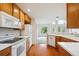 Galley kitchen featuring wooden cabinets, white appliances, and hardwood floors at 10725 Eliot Cir # 102, Denver, CO 80234