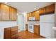 Bright kitchen featuring wood cabinets, appliances, and wood floors at 10725 Eliot Cir # 102, Denver, CO 80234