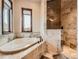 Beautiful bathroom with a soaking tub with travertine tile and glass enclosed shower at 15955 W 52Nd Dr, Golden, CO 80403