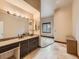 Bathroom boasts a double vanity with granite countertops and a large mirror. The bathroom has lots of natural light at 15955 W 52Nd Dr, Golden, CO 80403