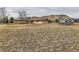 Wide shot of the side of the house with a large, expansive yard and partial view of the surrounding mountains at 15955 W 52Nd Dr, Golden, CO 80403