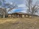 Exterior shot of a home with stone accents, a spacious front lawn, and a wide covered porch at 15955 W 52Nd Dr, Golden, CO 80403