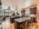 Spacious kitchen with granite countertops, wooden cabinets, island with seating, and wood flooring at 15955 W 52Nd Dr, Golden, CO 80403