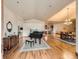 Open-concept living room featuring hardwood floors, piano, dining area, and elegant chandelier at 15955 W 52Nd Dr, Golden, CO 80403