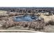 Scenic aerial view of a tranquil pond with gazebo, surrounded by park and neighborhood at 7559 Jay Ct, Arvada, CO 80003