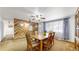 Dining room features wood wall paneling, large window, and a ceiling fan with lights at 7559 Jay Ct, Arvada, CO 80003