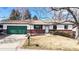 Inviting single-story home with green garage door, brick details, and manicured yard at 7559 Jay Ct, Arvada, CO 80003