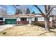 Charming single-story home featuring a green garage door, brick accents, and a well-maintained front yard at 7559 Jay Ct, Arvada, CO 80003