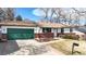 Charming single-story home with a green garage door, brick accents and well-maintained landscaping at 7559 Jay Ct, Arvada, CO 80003