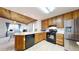 A sunny kitchen featuring wood cabinets, black appliances, and a stainless steel refrigerator at 7559 Jay Ct, Arvada, CO 80003