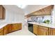 Open kitchen featuring wood cabinets, breakfast bar, white countertop, and open view to the living area at 7559 Jay Ct, Arvada, CO 80003