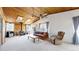 Cozy living room with wood-paneled ceiling, wood burning stove, and a ceiling fan at 7559 Jay Ct, Arvada, CO 80003