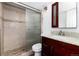 Updated bathroom featuring a granite vanity, a modern faucet, and tiled shower with glass door at 8757 Estes Ct, Arvada, CO 80005