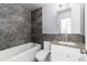 Updated bathroom features a tub, tiled wall, granite countertops, and a modern sink at 8757 Estes Ct, Arvada, CO 80005