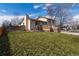 Back exterior of the property features a wooden deck, brick patio, and a well manicured lawn at 8757 Estes Ct, Arvada, CO 80005