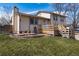 Back exterior of the property features a wooden deck, brick patio, and a well manicured lawn at 8757 Estes Ct, Arvada, CO 80005