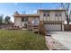 Inviting home with two-car garage, featuring a charming front yard and quaint wooden staircase at 8757 Estes Ct, Arvada, CO 80005