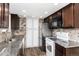 Bright kitchen with dark wood cabinets, stainless steel appliances, and stone countertops at 8757 Estes Ct, Arvada, CO 80005