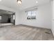 Open living room with neutral carpeting connecting to a living area with a stone fireplace at 8757 Estes Ct, Arvada, CO 80005