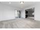 Open living room with neutral carpeting leading to the kitchen and a sliding glass door to the deck at 8757 Estes Ct, Arvada, CO 80005