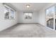 Bright living room featuring neutral carpeting, large windows, and a sliding glass door to the deck at 8757 Estes Ct, Arvada, CO 80005