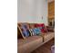 A comfy brown couch is decorated with colorful patterned pillows in living area at 2630 Juniper Ave # 37-5, Boulder, CO 80304