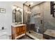 Modern bathroom with glass shower, tiled walls, wooden vanity, unique globe lights and hardware at 3059 N Humboldt St, Denver, CO 80205