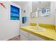 Cozy bathroom featuring a bright yellow countertop, blue shelving, and a mirrored medicine cabinet at 3832 S Quebec St, Denver, CO 80237