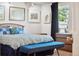Bedroom featuring a bed, a blue bench, carpet, a window with dark curtains, and stylish wall art at 3832 S Quebec St, Denver, CO 80237