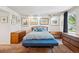 Comfortable bedroom showcasing a bed, bench, dresser, and stylish decorative wall art at 3832 S Quebec St, Denver, CO 80237