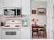 Bright, updated kitchen with white appliances, countertops and cabinets, and an adjacent dining area at 3832 S Quebec St, Denver, CO 80237