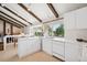 Modern kitchen with white cabinets, countertops, and a bright window overlooking the backyard at 3832 S Quebec St, Denver, CO 80237