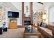 Cozy living room with brick fireplace and built-in bookcase at 3832 S Quebec St, Denver, CO 80237
